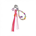 Pink tassel bag charm with colorful beaded "Love" loop and purple gummy bear charm – product view