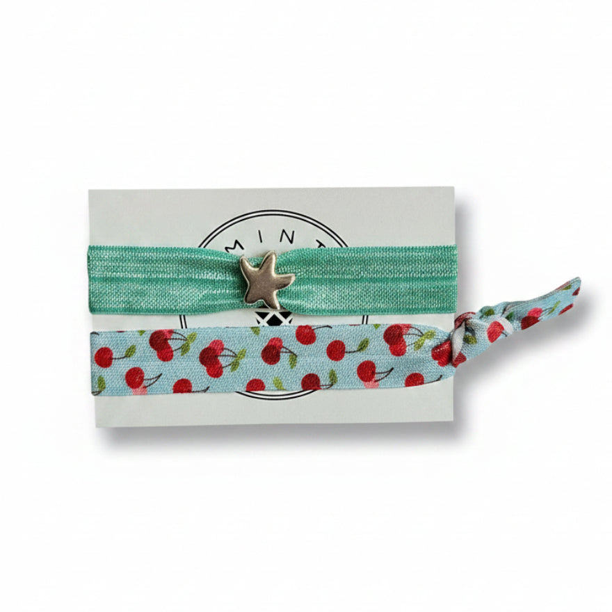 Mint elastic hair tie set with cherry print band and silver starfish charm on Mint Sorbet packaging card