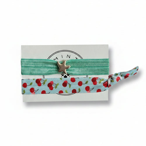 Mint elastic hair tie set with cherry print band and silver starfish charm on Mint Sorbet packaging card