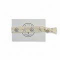 Beige elastic bracelet with silver seashell and starfish print on Mint Sorbet packaging card