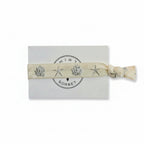 Beige elastic bracelet with silver seashell and starfish print on Mint Sorbet packaging card