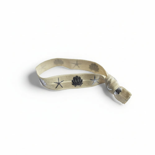 Beige elastic bracelet with silver seashell and starfish print – product view
