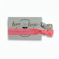 White "Love" print and coral elastic hair tie set on Mint Sorbet packaging card