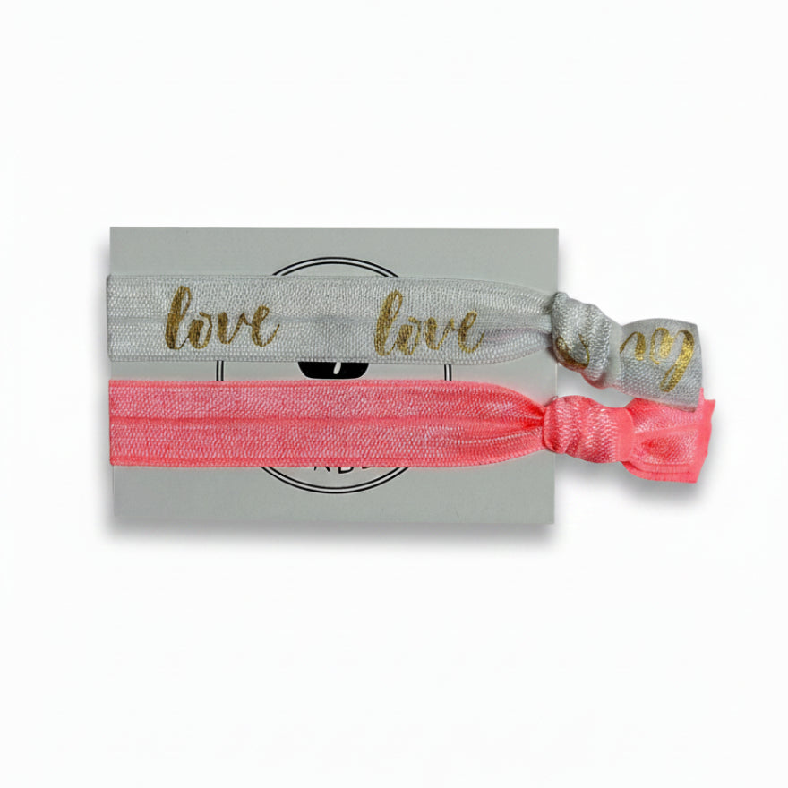 White "Love" print and coral elastic hair tie set on Mint Sorbet packaging card