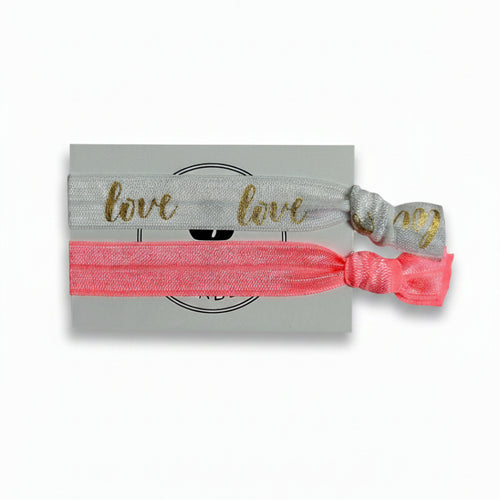 White "Love" print and coral elastic hair tie set on Mint Sorbet packaging card