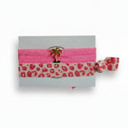 Pink elastic hair tie set with leopard print band and gold palm tree charm on Mint Sorbet packaging card