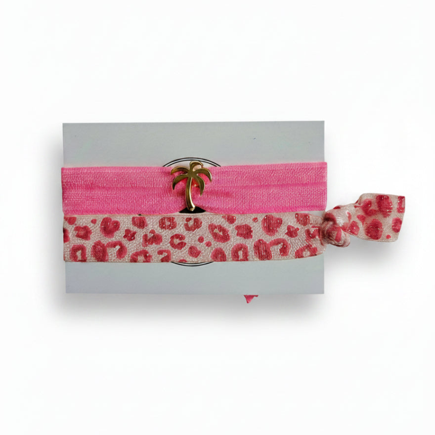 Pink elastic hair tie set with leopard print band and gold palm tree charm on Mint Sorbet packaging card