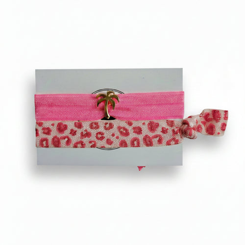 Pink elastic hair tie set with leopard print band and gold palm tree charm on Mint Sorbet packaging card