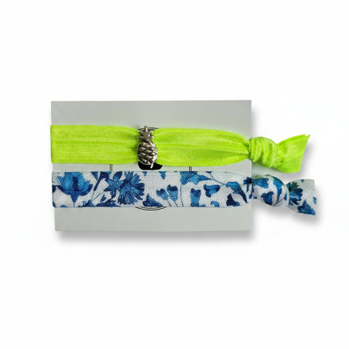 Neon yellow elastic hair tie set with blue floral band and silver pineapple charm on Mint Sorbet packaging card