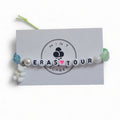 Handmade Eras Tour friendship bracelet with letter beads, heart bead and teddy bear charm on Mint Sorbet packaging card