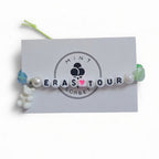 Handmade Eras Tour friendship bracelet with letter beads, heart bead and teddy bear charm on Mint Sorbet packaging card