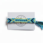 Hand-knotted blue and yellow cotton friendship bracelet with diamond pattern on Mint Sorbet packaging card