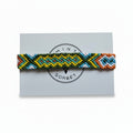 Hand-knotted green, yellow and orange cotton friendship bracelet with diamond pattern on Mint Sorbet packaging card