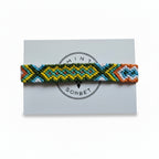 Hand-knotted green, yellow and orange cotton friendship bracelet with diamond pattern on Mint Sorbet packaging card