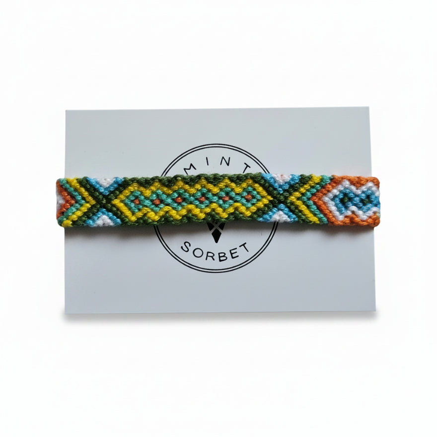 Hand-knotted green, yellow and orange cotton friendship bracelet with diamond pattern on Mint Sorbet packaging card