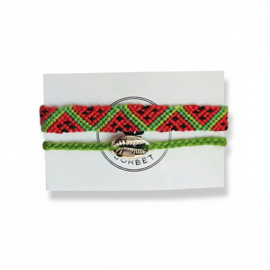 Red and green hand-knotted cotton friendship bracelet set with chevron pattern and green cord bracelet with silver cowrie shell charm on Mint Sorbet packaging card