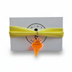 Yellow nylon elastic bracelet with orange acrylic ice cream cone pendant on Mint Sorbet packaging card