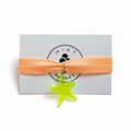 Peach nylon elastic bracelet with neon green acrylic starfish pendant on Mint Sorbet packaging card