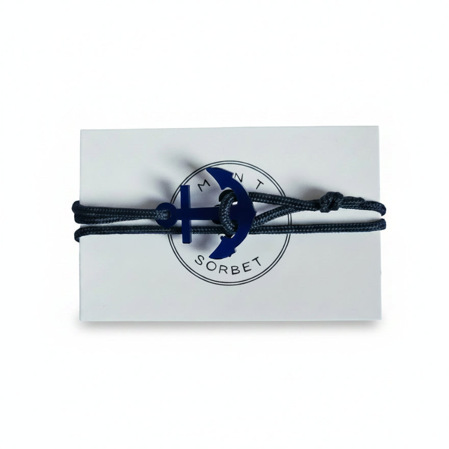 Dark blue paracord bracelet with blue acrylic anchor pendant on Mint Sorbet packaging card