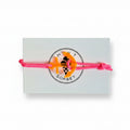 Pink paracord bracelet with neon orange acrylic anchor pendant on Mint Sorbet packaging card