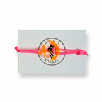 Pink paracord bracelet with neon orange acrylic anchor pendant on Mint Sorbet packaging card