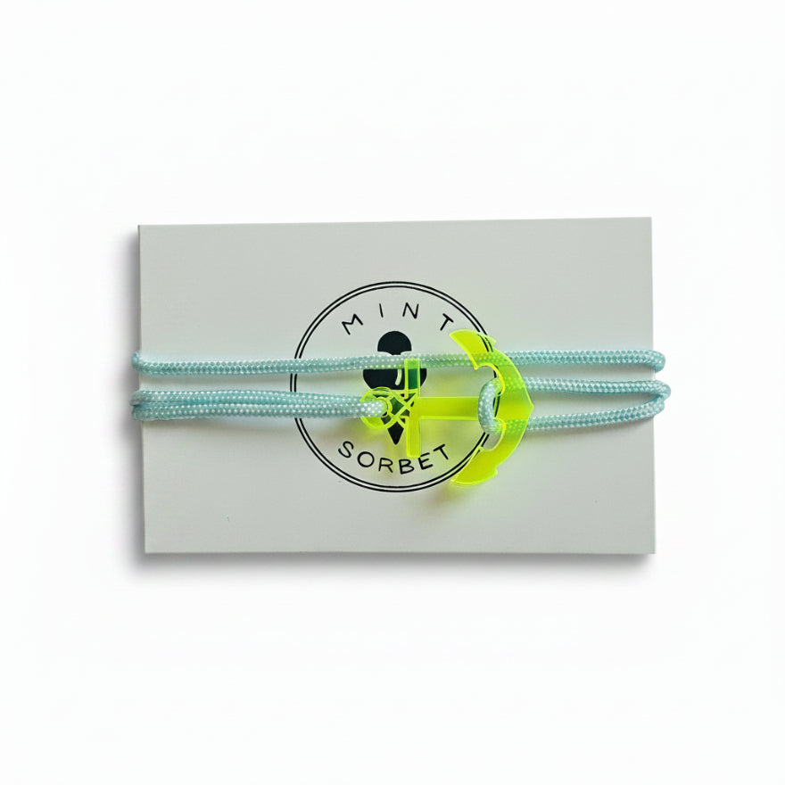 Light blue paracord bracelet with neon yellow acrylic anchor pendant on Mint Sorbet packaging card