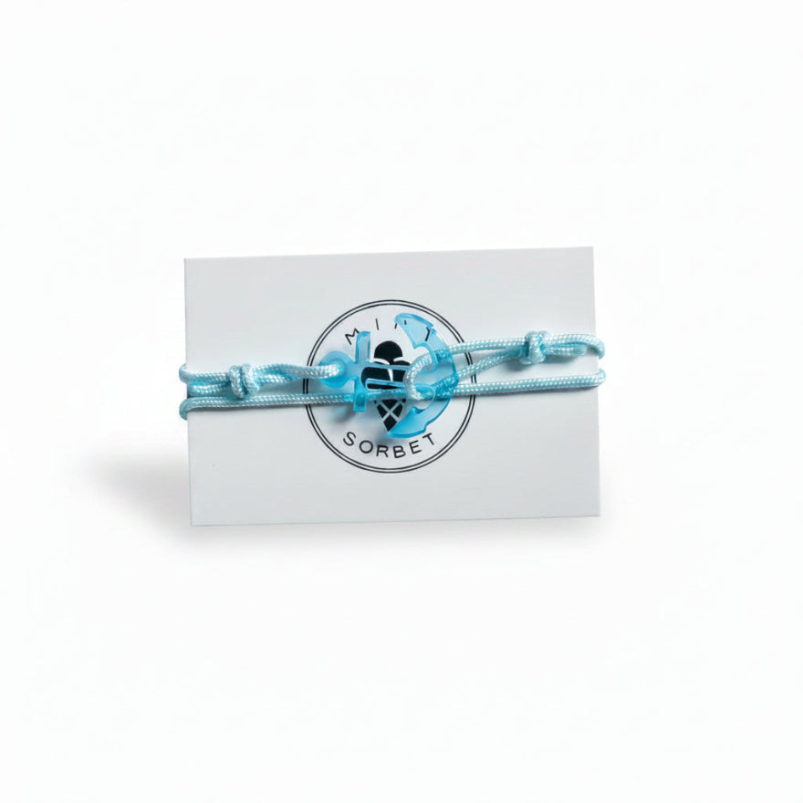Light blue paracord bracelet with transparent blue acrylic anchor pendant on Mint Sorbet packaging card